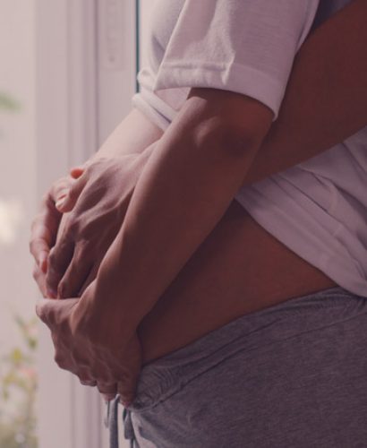 Young Asian Pregnant couple hug and holding belly talking with their child. Mom and Dad feeling happy smiling peaceful while take care baby, pregnancy near window in living room at home concept.